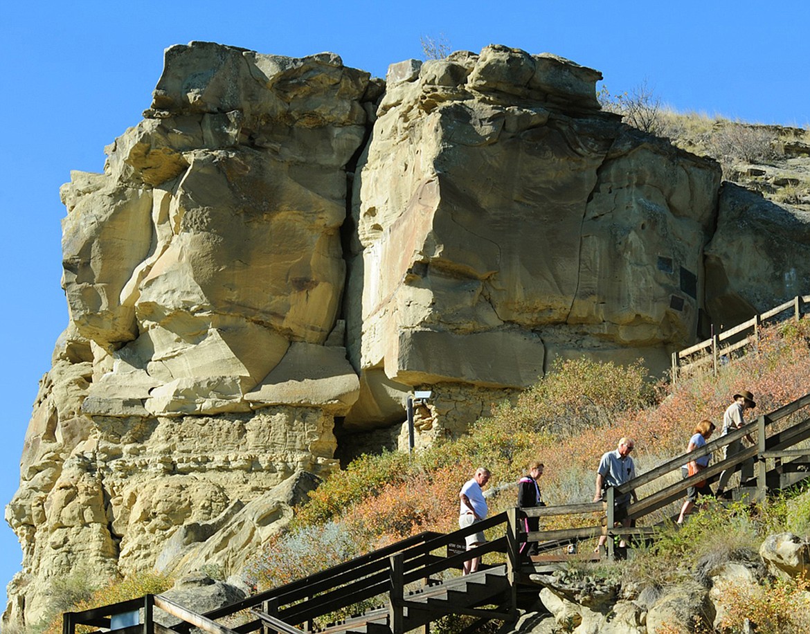 Tourists make their way up the stairs to William Clark's signature at Pompeys Pillar along the Lewis and Clark Trail in southeastern Montana in 2014. The U.S. Bureau of Land Management is proposing work to keep the historic sandstone landmark near the Yellowstone River east of Billings from falling apart or eroding further. The sandstone is also engraved with over 5,000 other etchings, petroglyphs and pictographs, according to the National Park Service. (Larry Mayer/The Billings Gazette via AP)