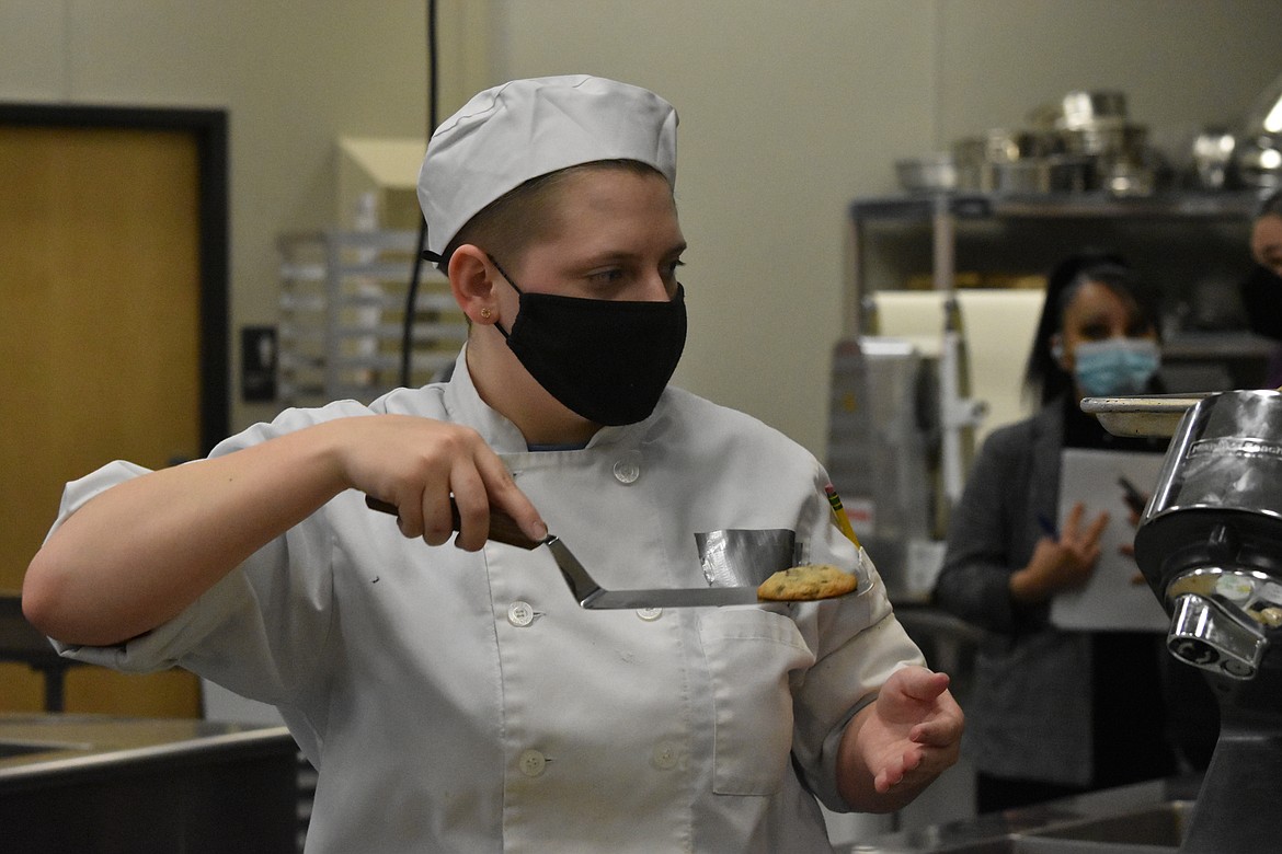 Klair Reed moves her cookies to the sheet that she will use for presentation to the judges.