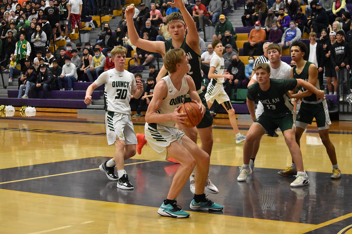 Quincy High School sophomore Aidan Bews (4) looks for an opening to attempt a shot during the district championship on Feb. 11.