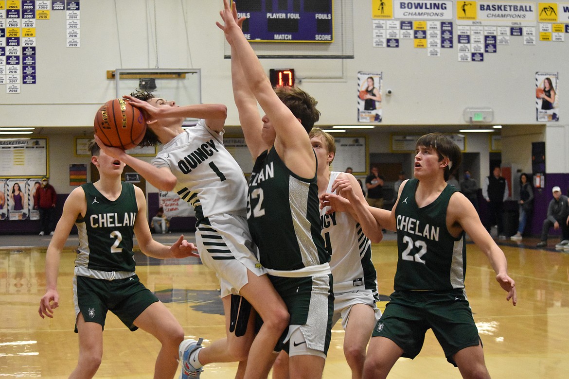 Quincy High School senior TreyVaughn Bierlink (1) shoots the ball on Feb. 11 in the district championship game as Chelan High School senior Reed Stamps (32) attempts to block the shot.