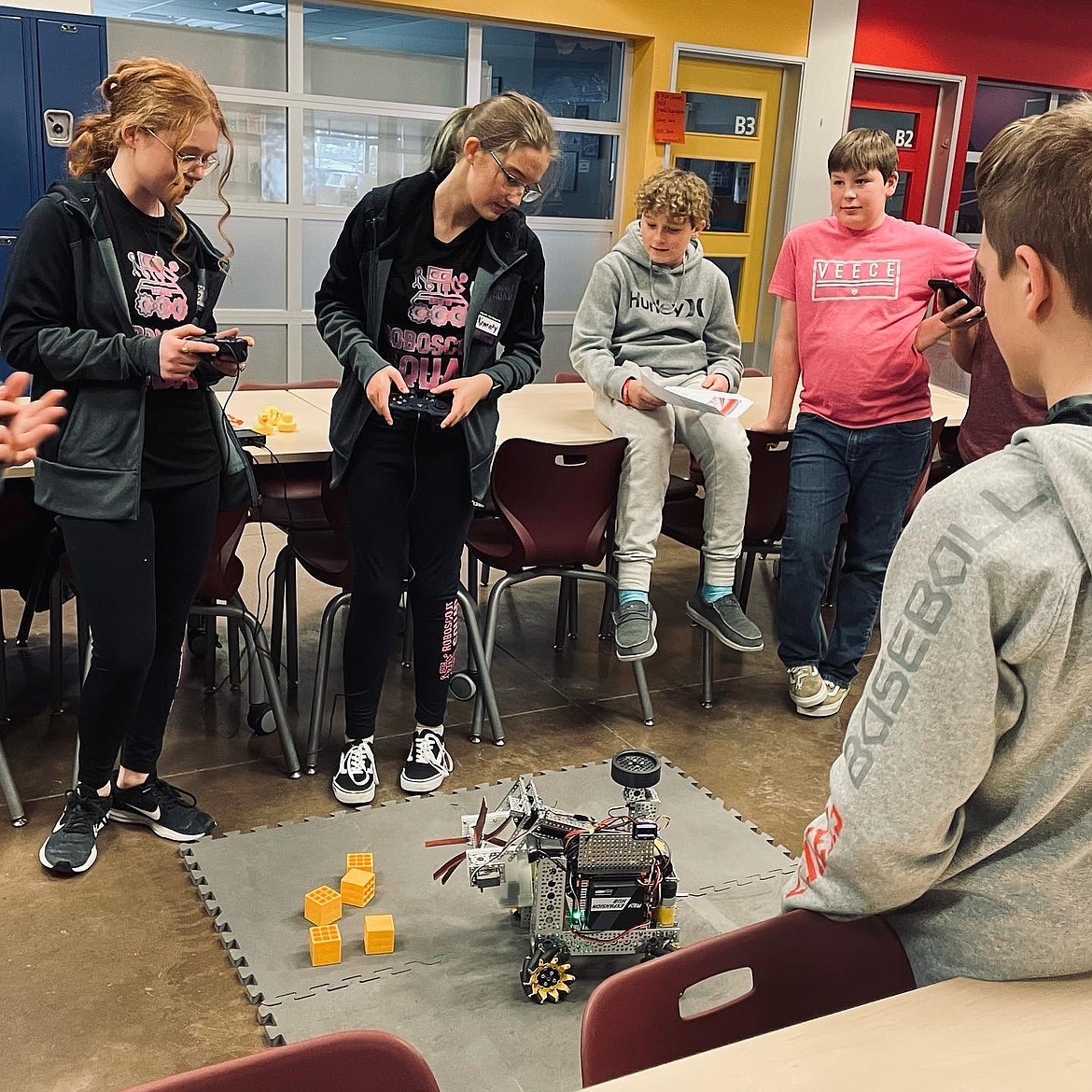 (L to R) RoboScout Squad members, Zia Walker and Kennedy Dortch, both sophomores at Flathead High School, lead a robotics demonstration at West Valley School as seventh-graders Brock Moloney and Thomas Airhart watch. The demonstration and scrimmage came ahead of state competitions set for Feb. 26 and March 6. (Photo provided)
