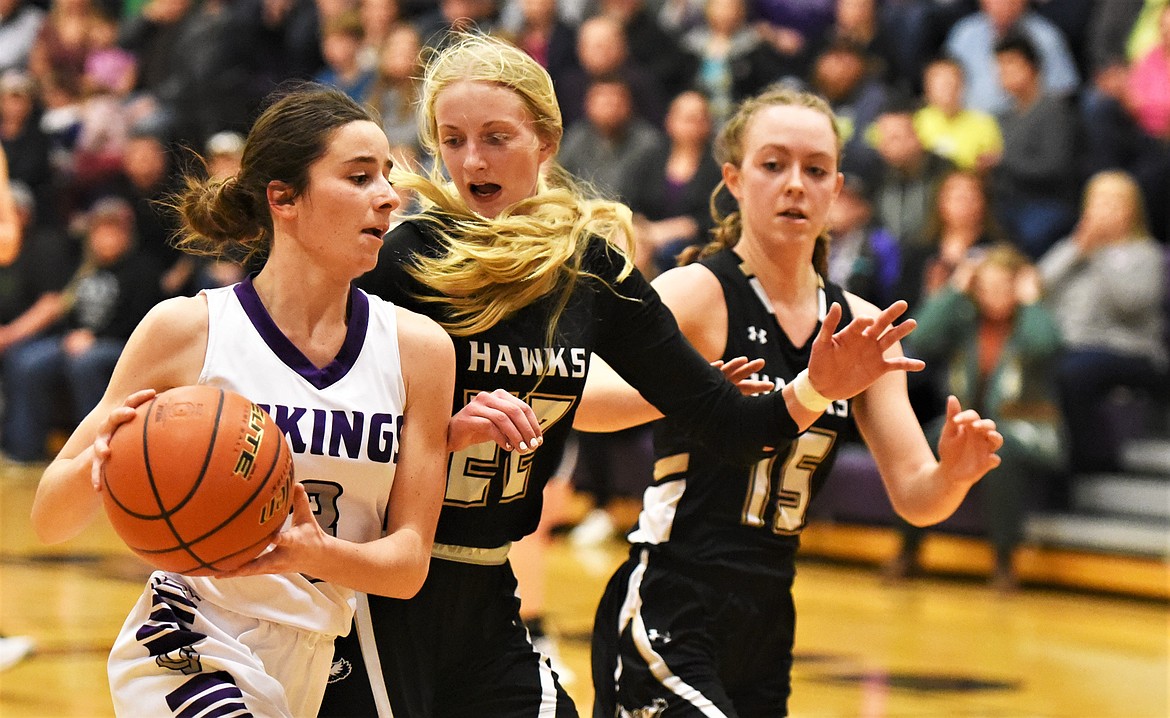 Charlo's Hayleigh Smith heads to the basket on a fast break as Seeley-Swan's Kyla Conley (22) and Sariah Maughan defend. (Scot Heisel/Lake County Leader)