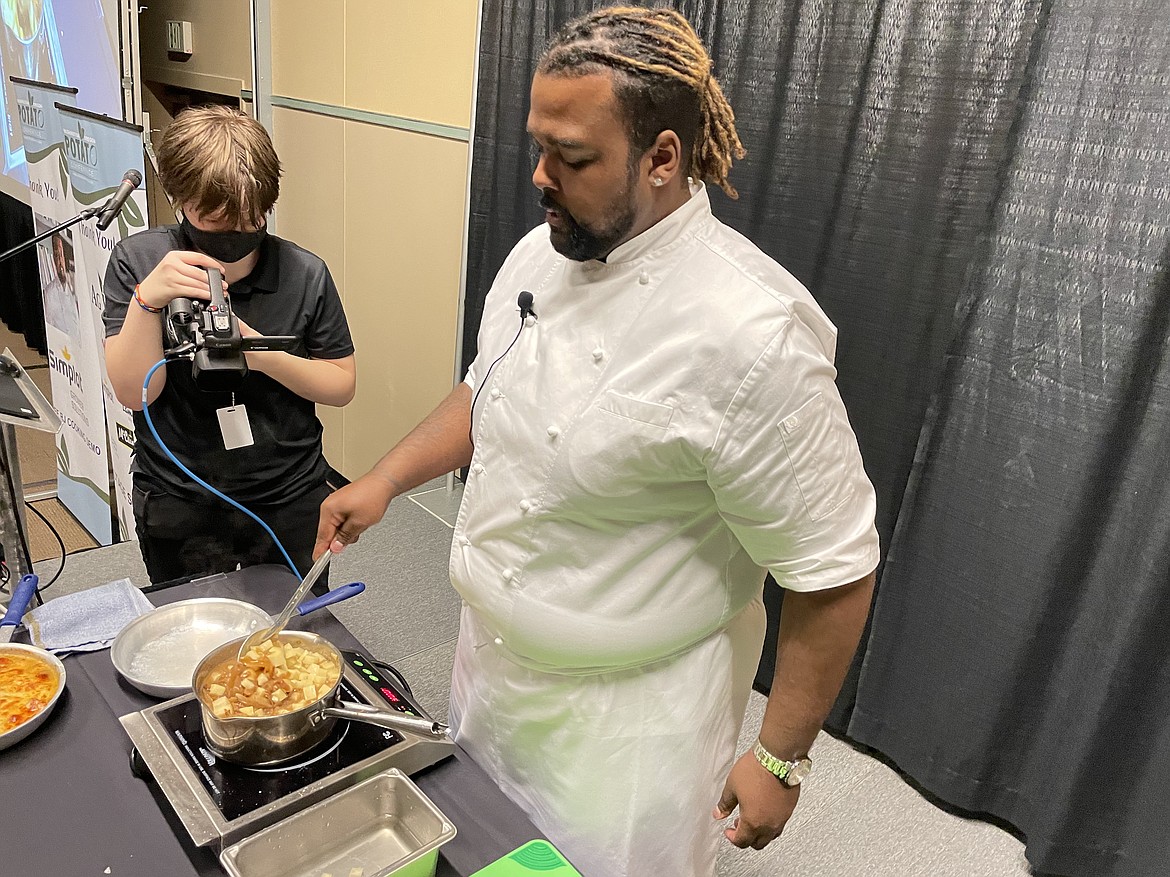 Chef RJ Harvey, culinary director for Potatoes USA, stirs a pot of broth, potatoes and caramelized onions during a cooking demonstration on making French onion potato casserole during the annual Washington Oregon Potato Conference in Kennewick last week.