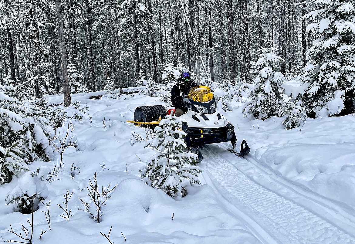 James Dean, Whitefish Bike Retreat operations manager, pulls the grooming tool behind a snowmobile while grooming the Beaver Lakes trails this winter. (Courtesy photo)