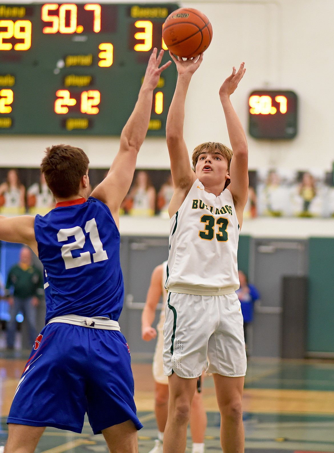 Bulldog senior Gabe Lund pops a jumper over Wildcat Bryce Dunham in a rivalry game on Saturday in Whitefish. (Whitney England/Whitefish Pilot)