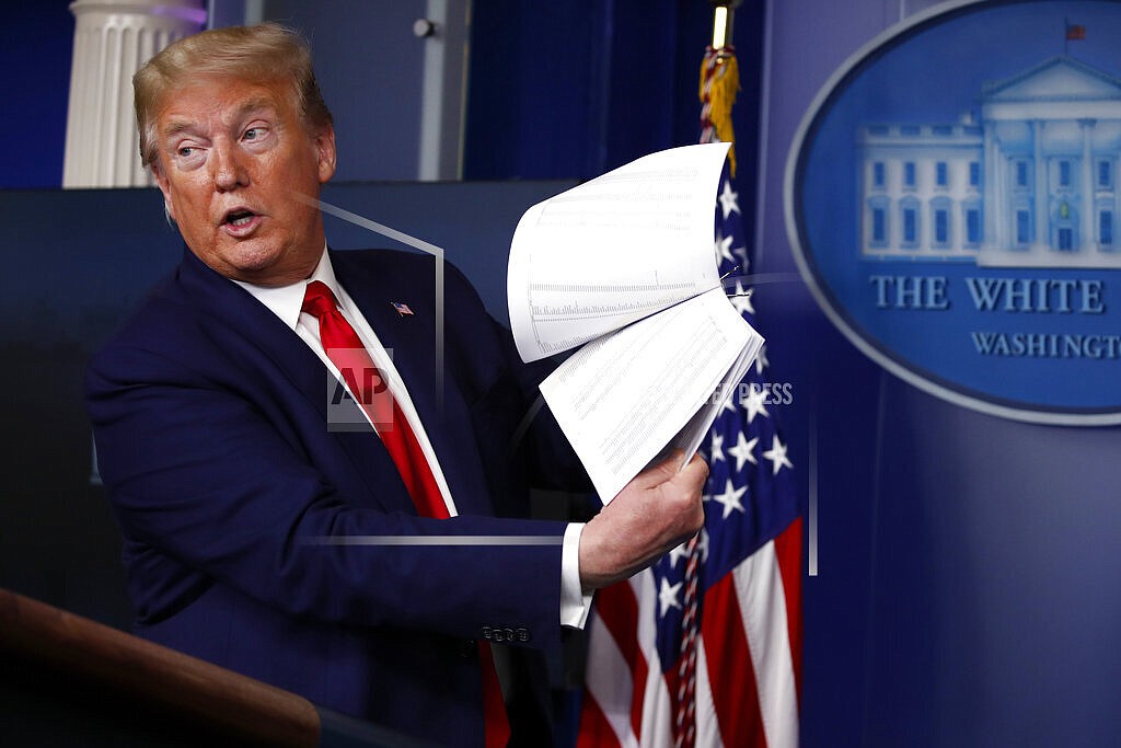President Donald Trump holds up papers as he speaks about the coronavirus in the James Brady Press Briefing Room of the White House on April 20, 2020, in Washington. President Joe Biden is ordering the release of Trump White House visitor logs to the House committee investigating the riot of Jan. 6, 2021, once more rejecting former President Donald Trump’s claims of executive privilege. The committee has sought a trove of data from the National Archives, including presidential records that Trump had fought to keep private. (AP Photo/Alex Brandon, File)