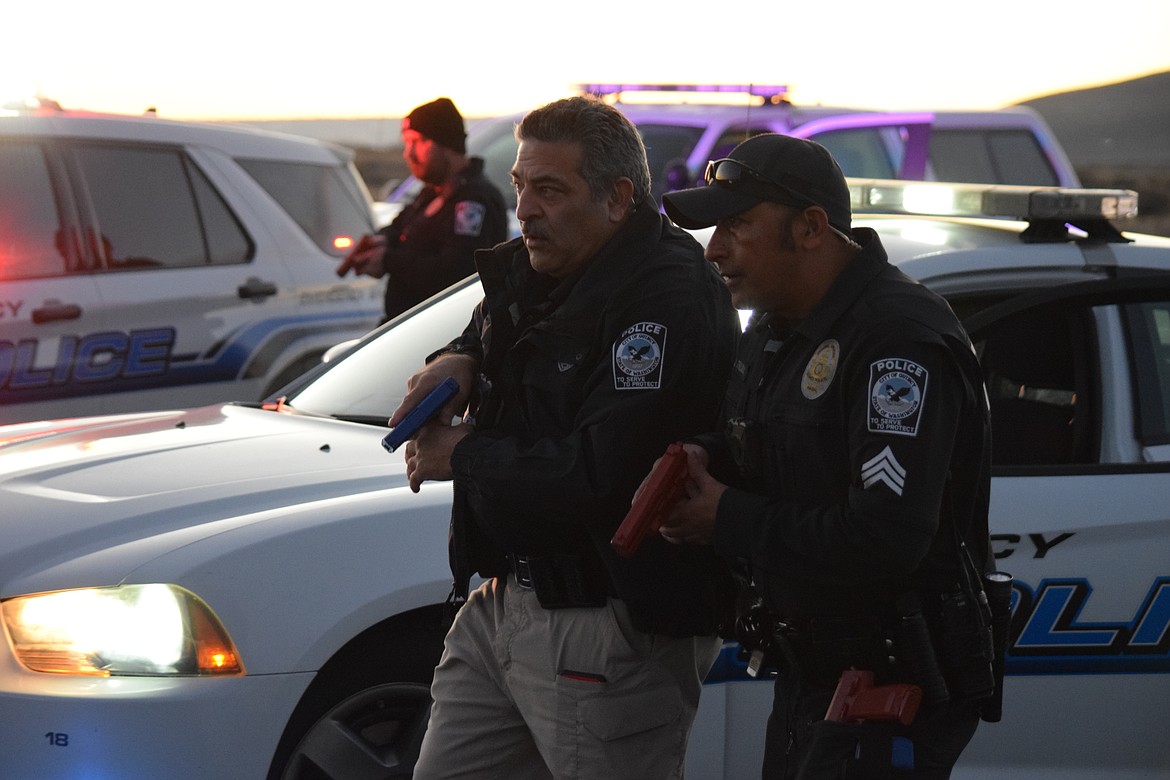 Quincy Police Officer Sal Mancini (left) and Sgt. Jorge Trujillo slowly advance on a suspect vehicle during a simulated high-risk traffic stop. Officers say they never know what can happen during a traffic stop.