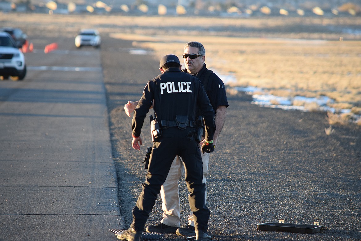 Quincy Police Officer Sal Mancini gives Officer Jerry Martinez some pointers on properly throwing a spike strip during the Tuesday training. Proper deployment of the spike strip takes practice.