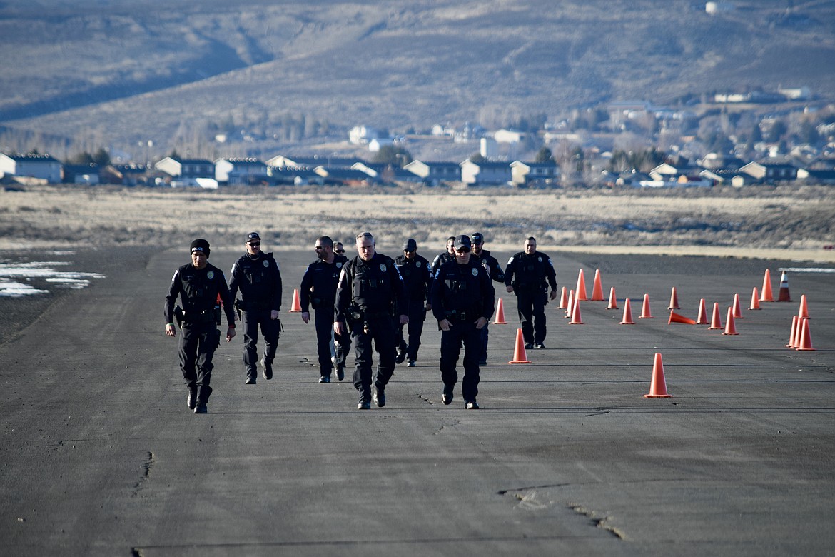 Officers with the Quincy Police Department walk down an unused runway at the Ephrata Municipal Airport after checking out the Emergency Vehicle Operations Course, which they all drove through twice during training on Tuesday.