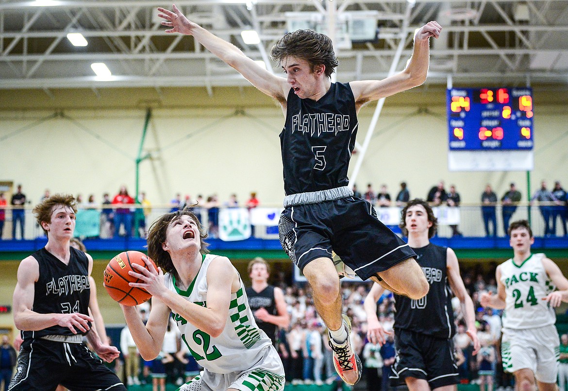 Glacier's Kyson Wagner (12) pump fakes and gets Flathead's Drew Lowry (5) up in the air in the second quarter at Glacier High School on Thursday, Feb. 17. (Casey Kreider/Daily Inter Lake)