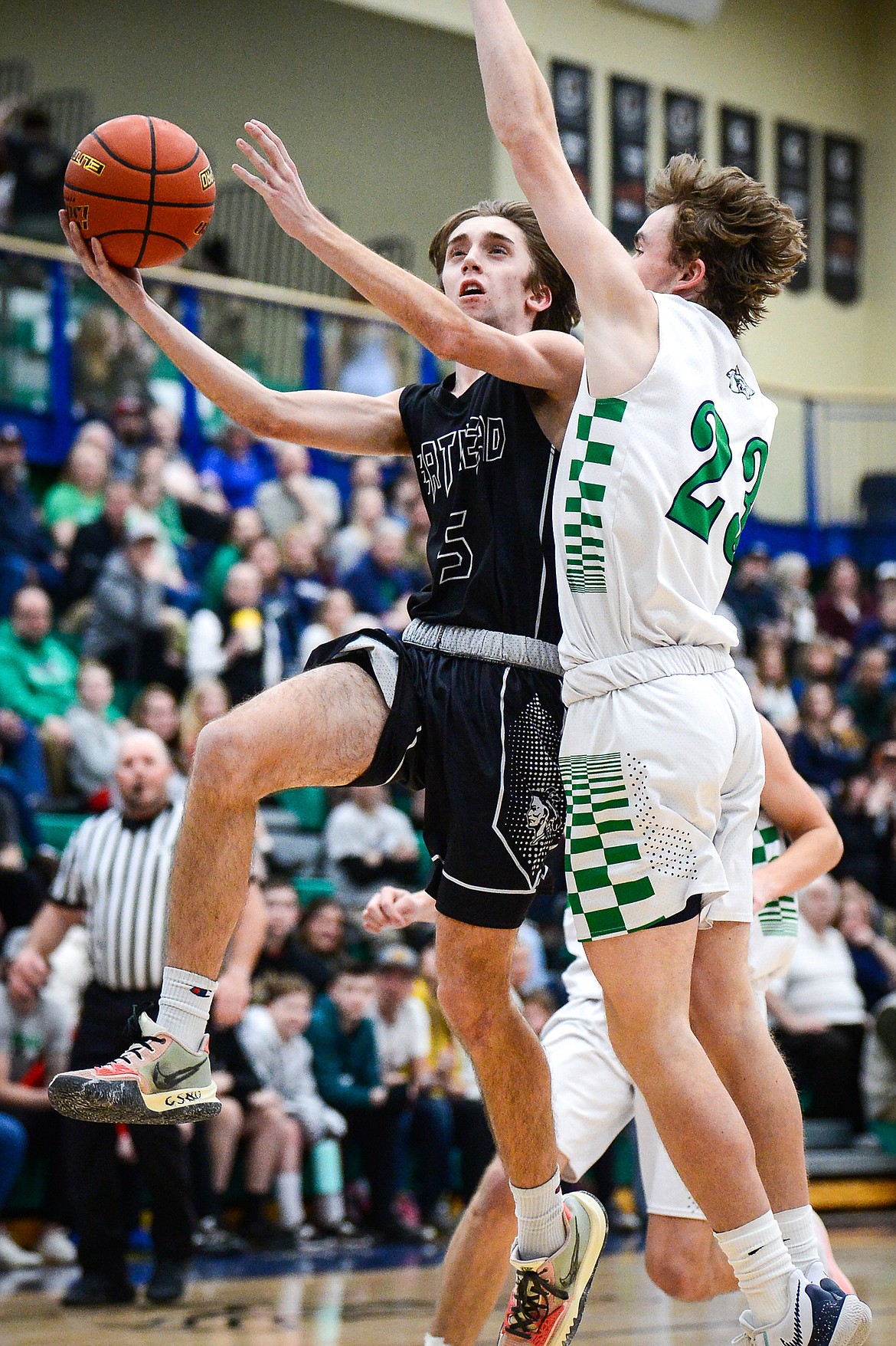 Flathead's Drew Lowry (5) drives to the basket against Glacier's Will Salonen (23) at Glacier High School on Thursday, Feb. 17. (Casey Kreider/Daily Inter Lake)