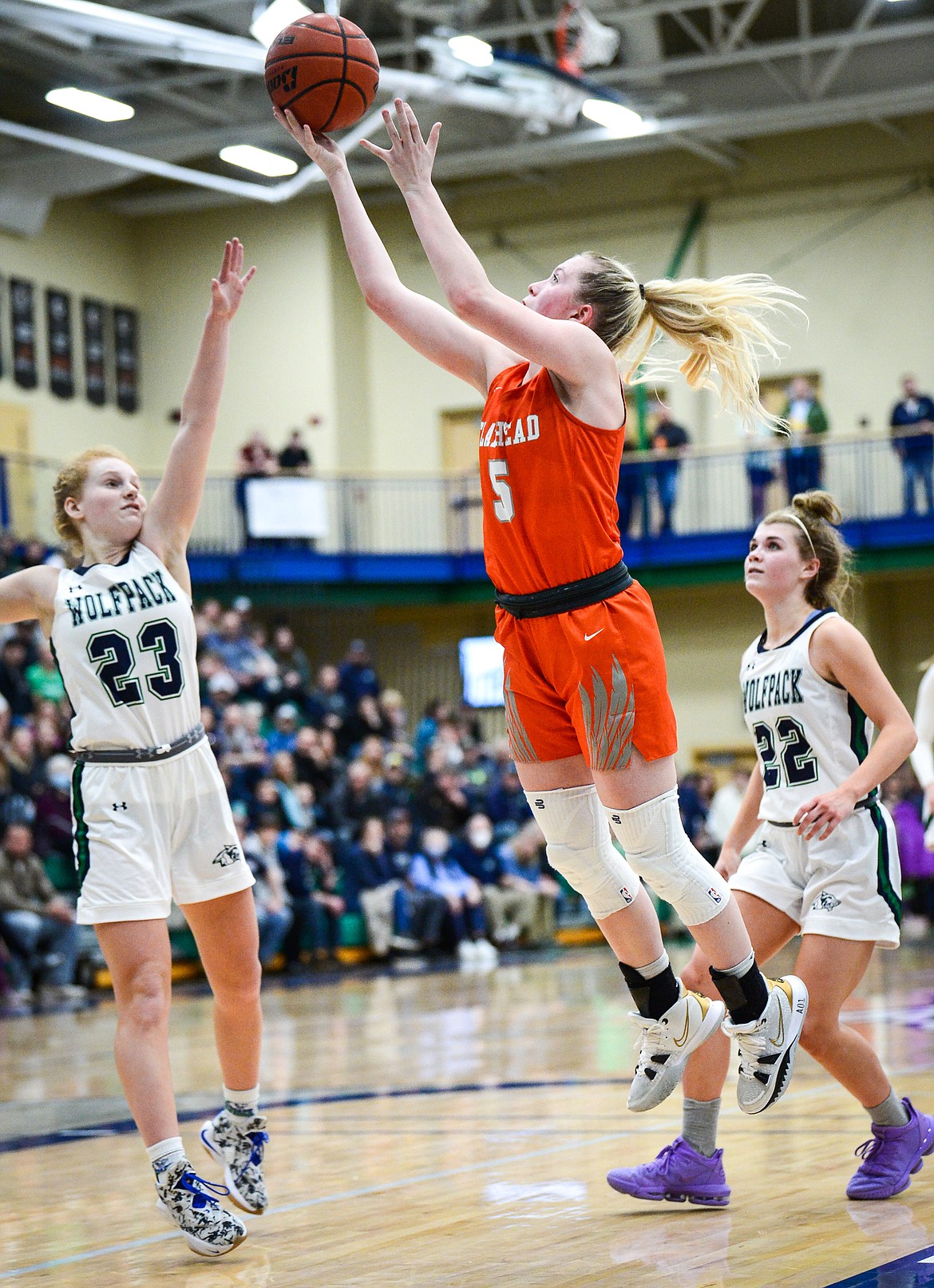 Flathead's Maddy Moy (5) goes to the basket between Glacier defenders Reese Ramey (23) and Noah Fincher (22) at Glacier High School on Thursday, Feb. 17. (Casey Kreider/Daily Inter Lake)