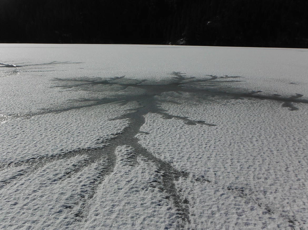 End-of-season ice on Fernan Lake, marked by open water along pressure cracks.