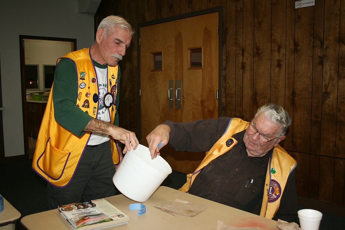 Ephrata Lions members Jerry Buchmann (left) and Lewis Wyman (right) draw to see who takes the prize during a meeting Feb. 15. The winner donated the money back to the club.