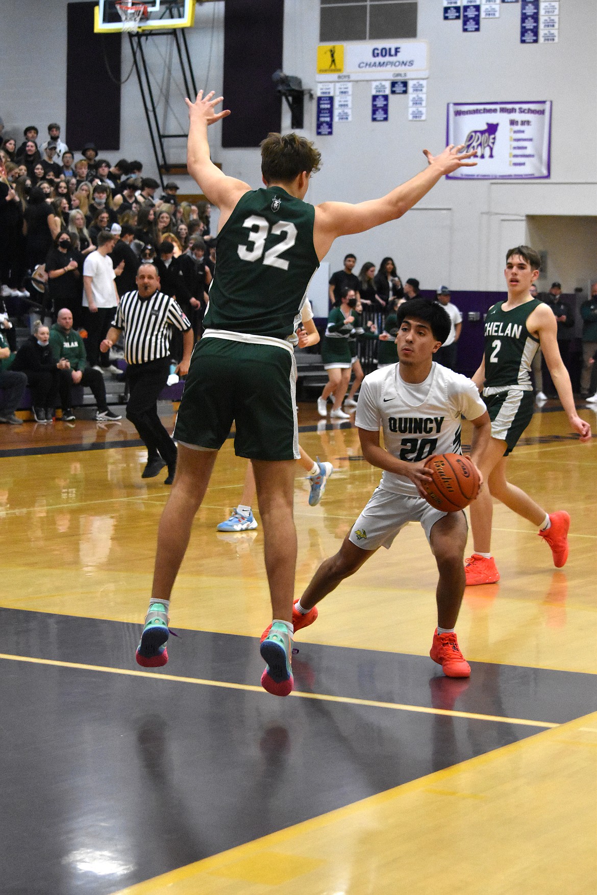 Quincy High School senior Saul Alvarez (20) as Chelan High School senior Reed Stamps (32) jumps to try to block any shot Alvarez might try to make during the district championship on Feb. 11.