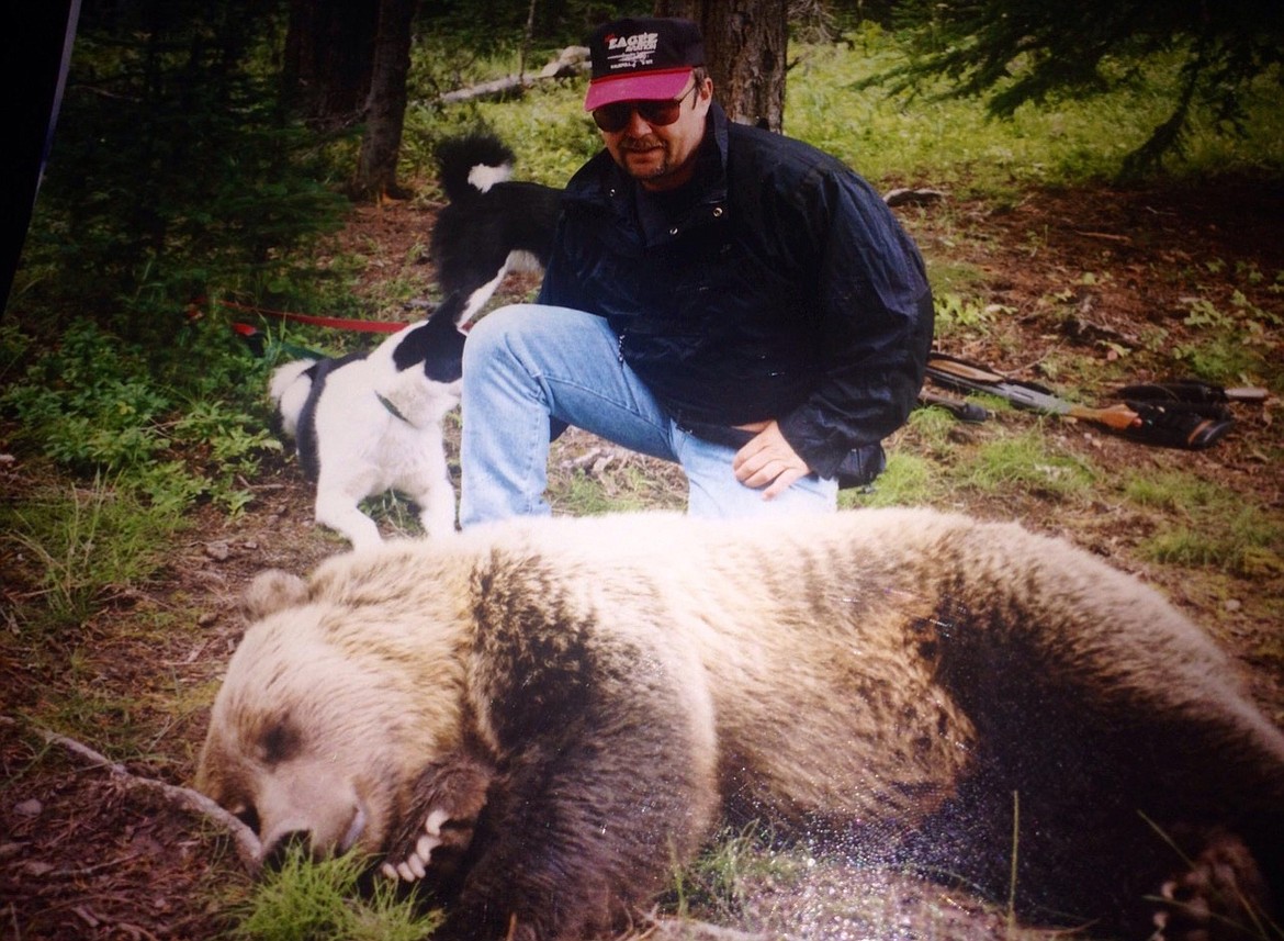 Pilot Dave Hoerner poses for a quick photo with a tranquilized grizzly cub before attempting to help the FWP to relocate the animal using his plane. (photo provided)