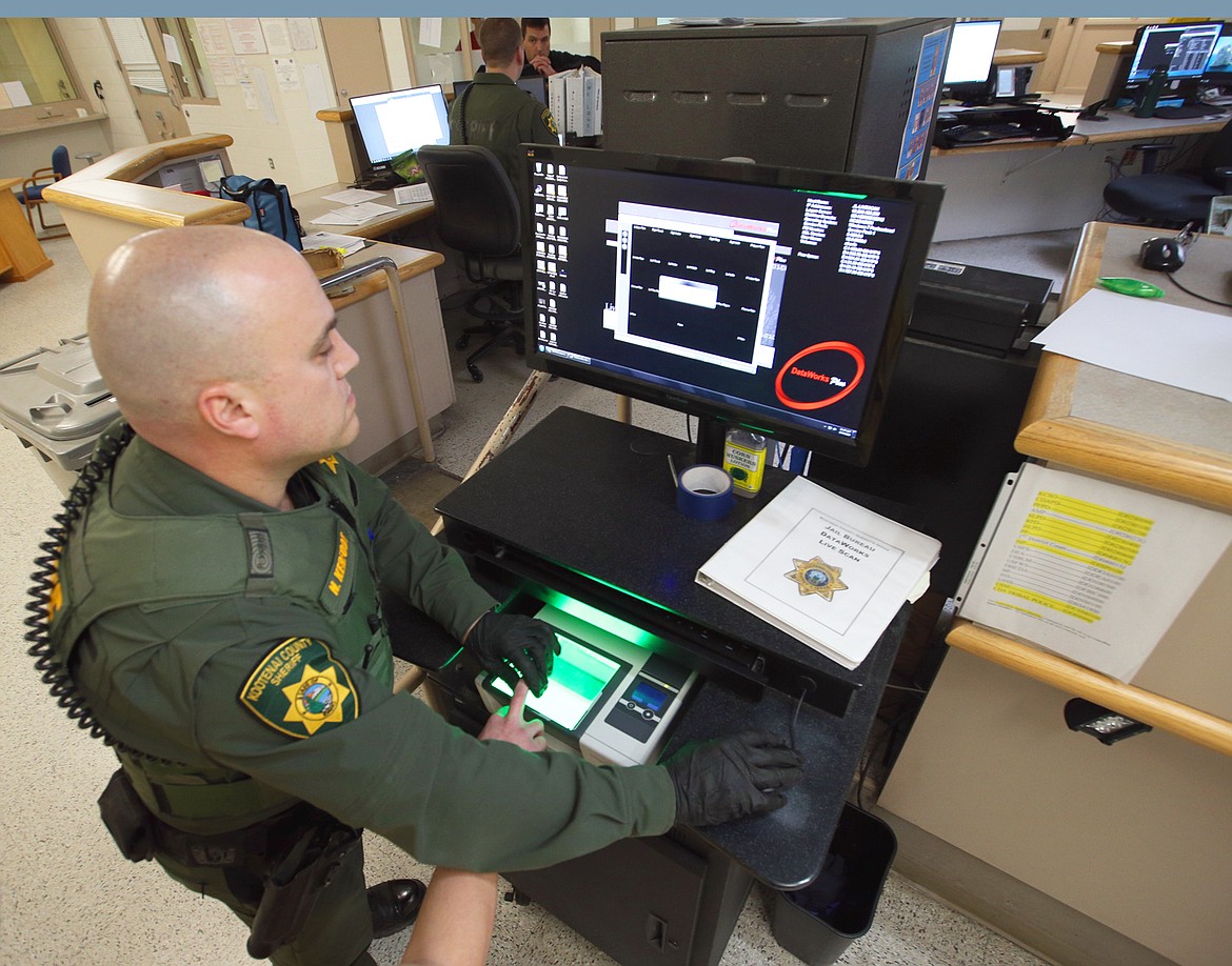 KCSO Detention Deputy Nick Kerfoot fingerprints an inmate at the Kootenai County jail on Thursday.