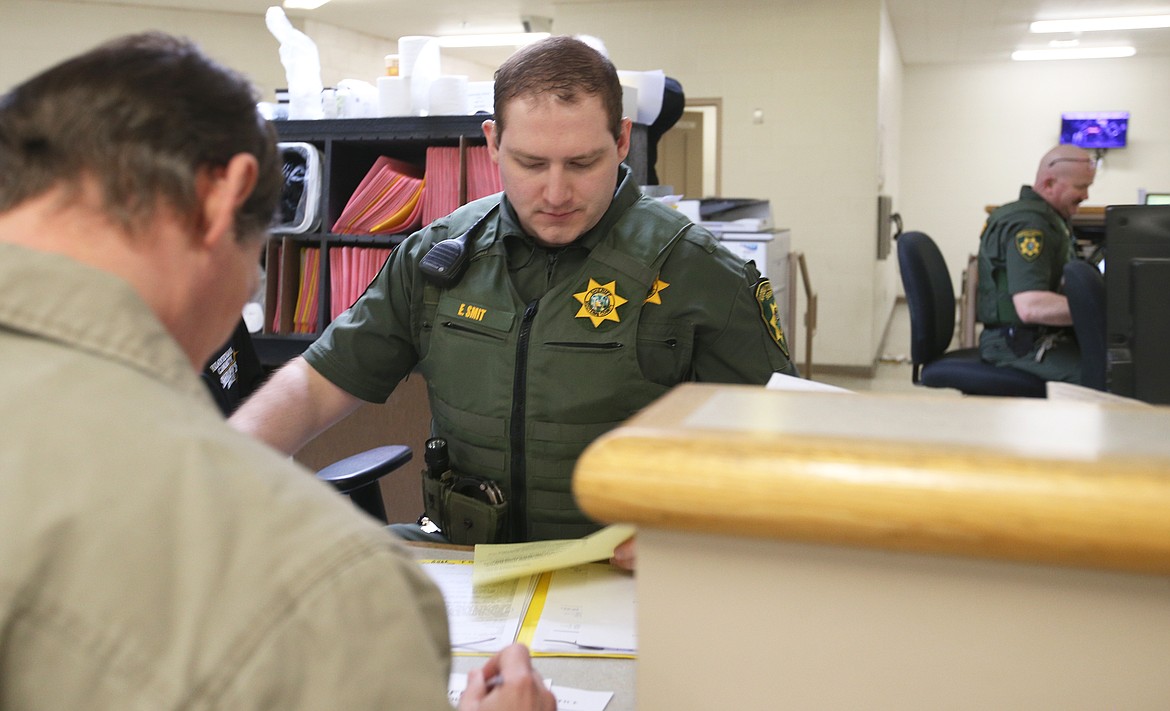 KCSO Detention Deputy Evan Smith processes release papers for a jail inmate on Thursday.