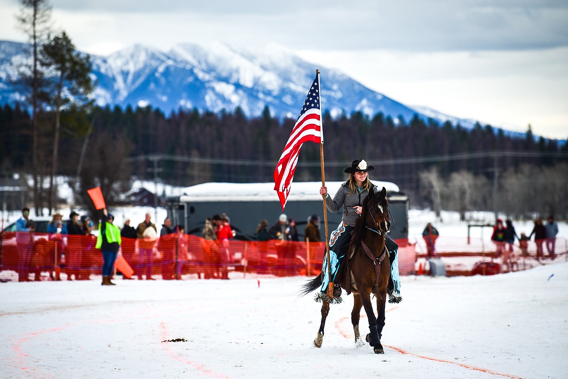 A rider carries the American flag through the course before the National Anthem is sung at Whitefish Ski Joring on Saturday, Feb. 19. (Casey Kreider/Daily Inter Lake)