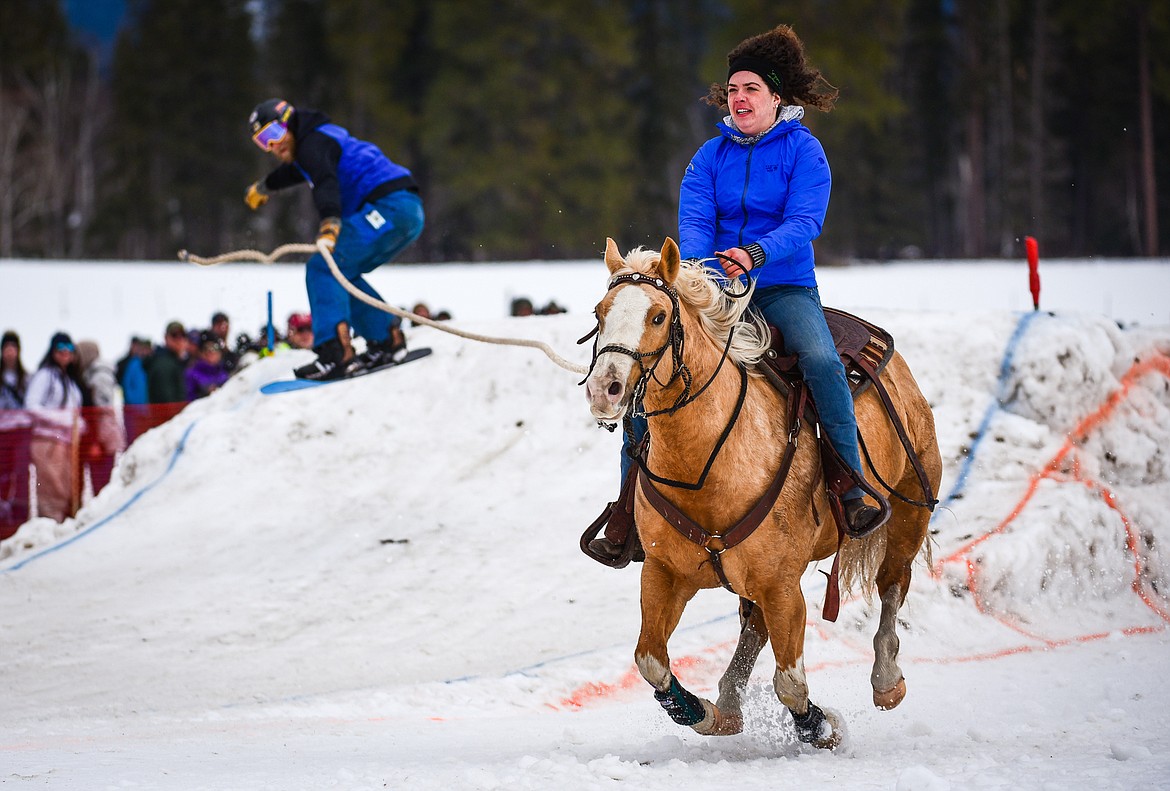 A rider and snowboarder navigate a jump in the course at Whitefish Ski Joring on Saturday, Feb. 19. (Casey Kreider/Daily Inter Lake)