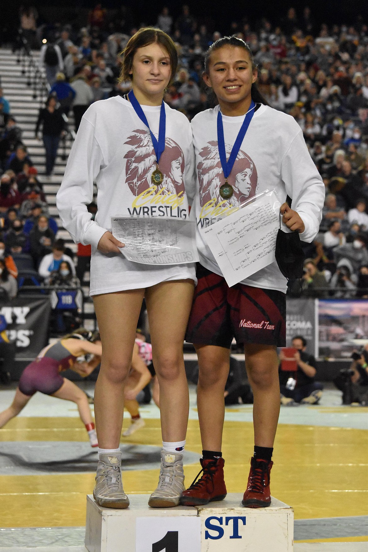 Moses Lake High School junior Bianca Johnson, left, and sophomore Ashley Dayana Naranjo, right, pose together on the podium at the WIAA Mat Classic XXXIII state wrestling tournament on Feb. 19. Both took first in their respective weight classes.