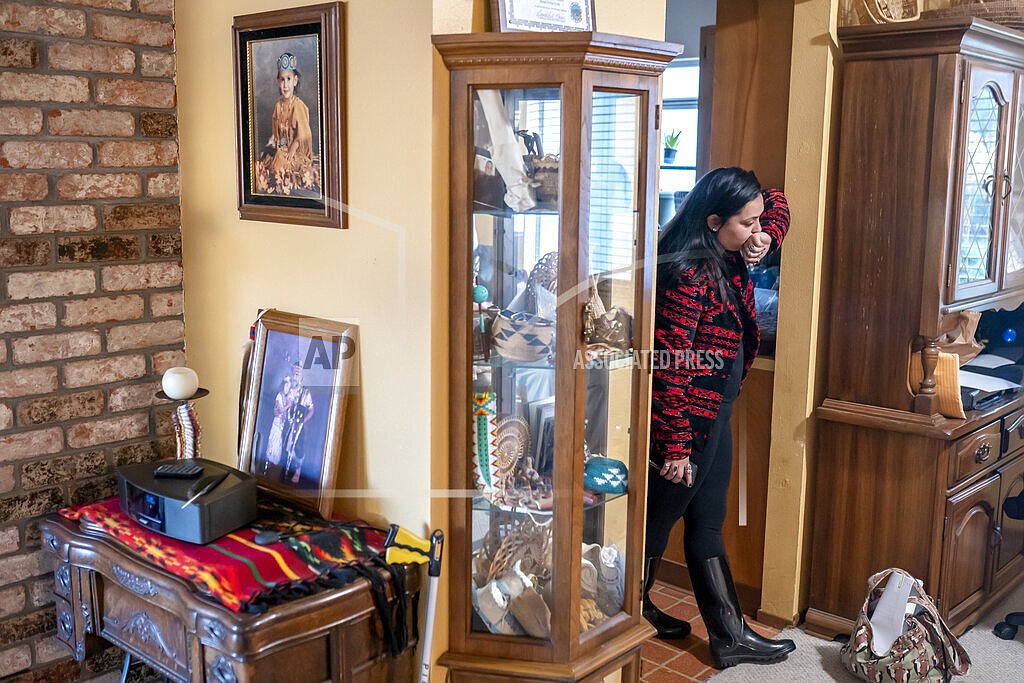 Mary Risling stands near a photo of her missing sister, Emmilee Risling, at the family home on Jan. 21, 2022, in McKinleyville, Calif. Emmilee Risling, a 33-year-old college graduate and an accomplished traditional dancer with ancestry from three area tribes, was last seen more than four months ago walking across a bridge near End of Road, a far corner of the Yurok Reservation where the rutted pavement dissolves into thick woods. Her disappearance is one of five instances in the past 18 months where Indigenous women have gone missing or been killed in an isolated expanse of Pacific coastline between San Francisco and Oregon, a region where the Yurok, Hupa, Karuk and Wiyot people have co-existed for millenia. (AP Photo/Nathan Howard)