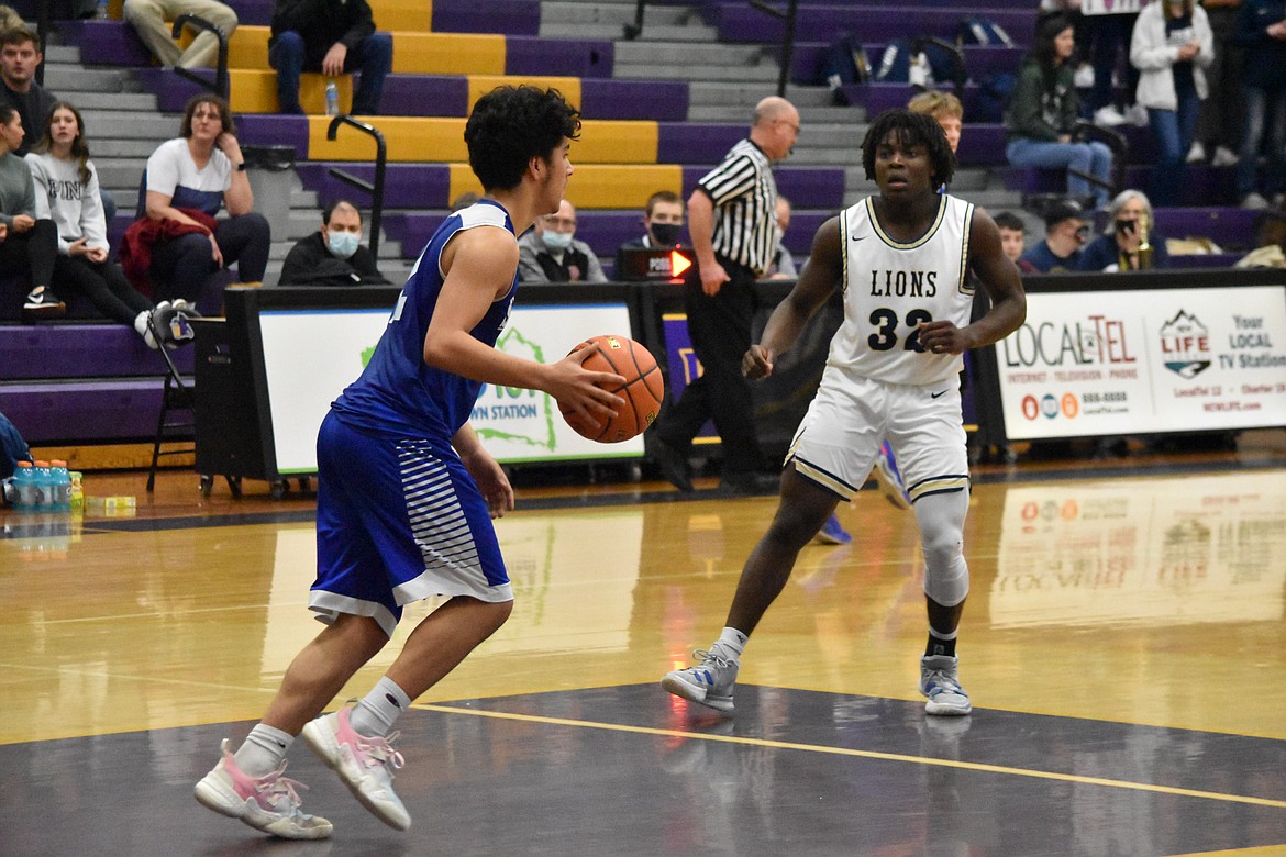 Soap Lake High School senior Diego Garza (2) takes the ball down court as MLCA/CCS senior Pierre Boorman (32) guards him.