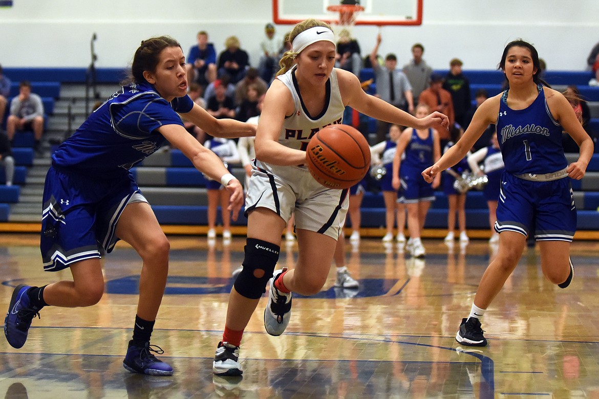 Plains forward Kaylah Standeford steals the ball from Mission's Madyson Currie during action in the District 7B Tournament in Bigfork Thursday.