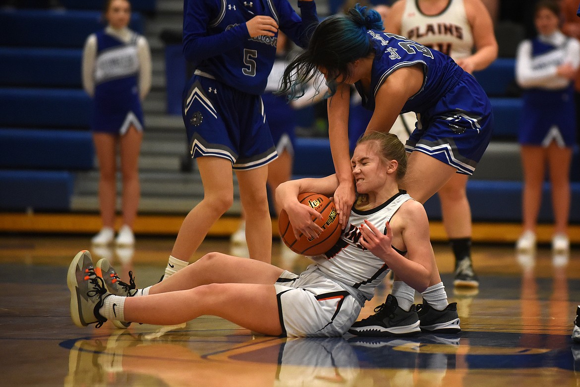 Plains guard Jaelyn Carr battles Mission's Oliviah Adams for a loose ball during action in the District 7B Tournament in Bigfork Thursday.