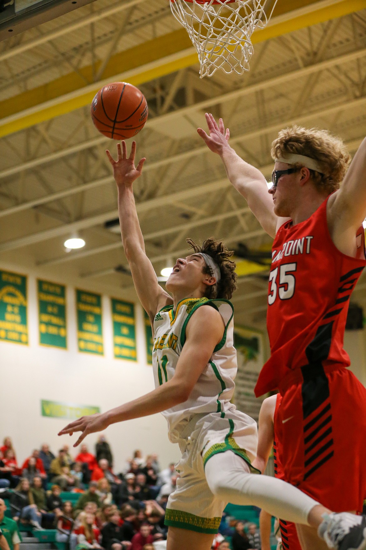 JASON DUCHOW PHOTOGRAPHY
Bryce Henry (11) of Lakeland tries a reverse layup as Ethan Butler (35) of Sandpoint defends in a 4A Region 1 boys basketball loser-out game Monday night at Hawk Court in Rathdrum.