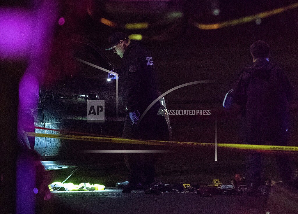 Portland police respond, on Saturday, Feb. 19, 2022, to a shooting in the area of Normandale Park in Northeast Portland, Ore. One person was killed and five others were wounded in a shooting at the Portland park where a march was planned to protest police violence. (Beth Nakamura/The Oregonian via AP)