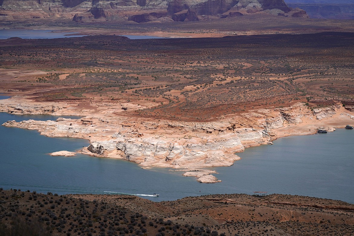 FILE - A boat moves along Wahweap Bay along the Upper Colorado River Basin, Wednesday, June 9, 2021, at the Utah and Arizona border near Wahweap, Ariz. The Biden administration will use $1.7 billion from the recently enacted federal infrastructure bill to fund 16 tribal water rights settlements. U.S. Interior Secretary Deb Haaland announced the funding Tuesday, Feb. 22, 2022 during a visit to Arizona. (AP Photo/Ross D. Franklin,File)