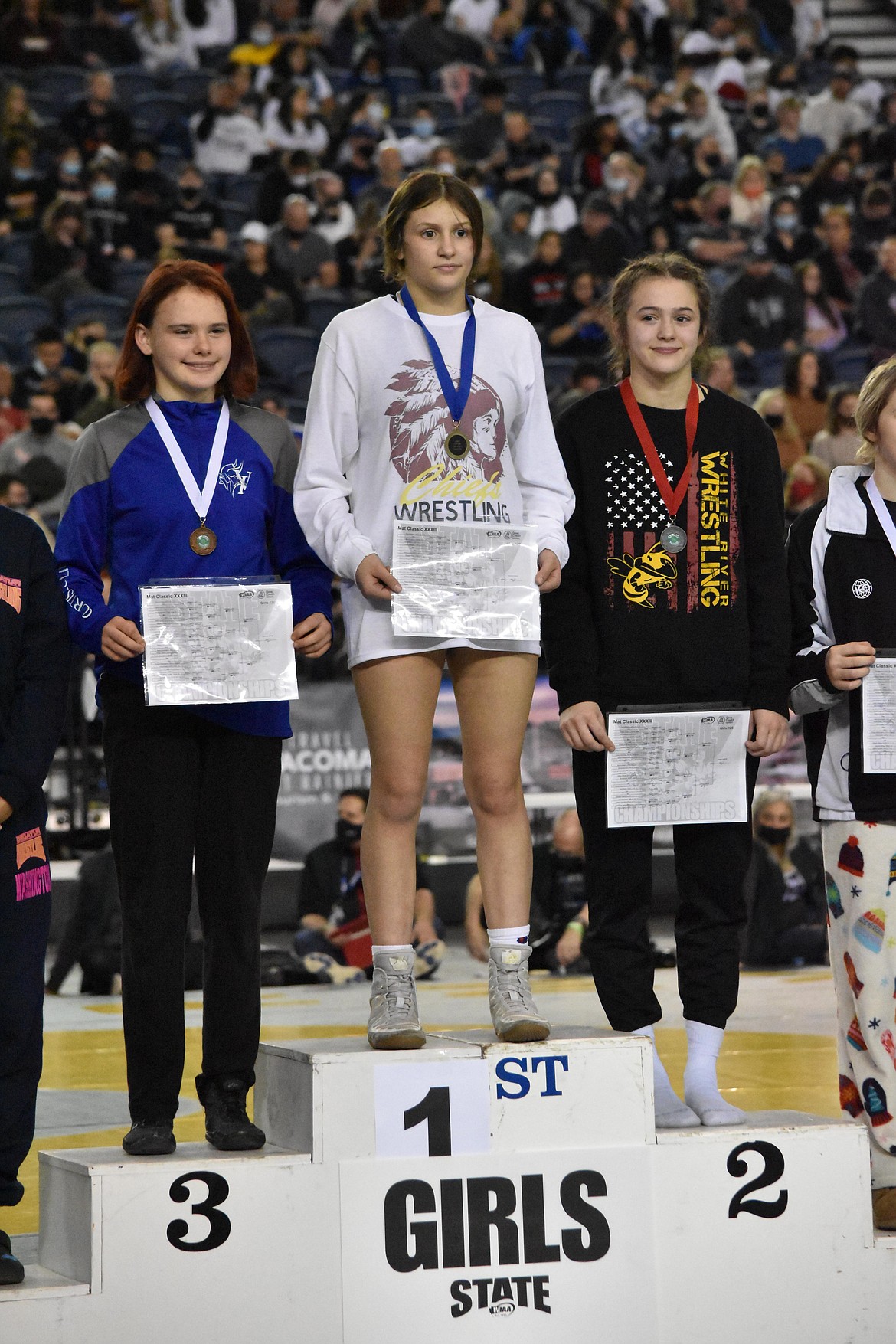 Moses Lake High School junior Bianca Johnson poses on the podium after winning the championship match to take the state title for the girls 120 pound weight class.