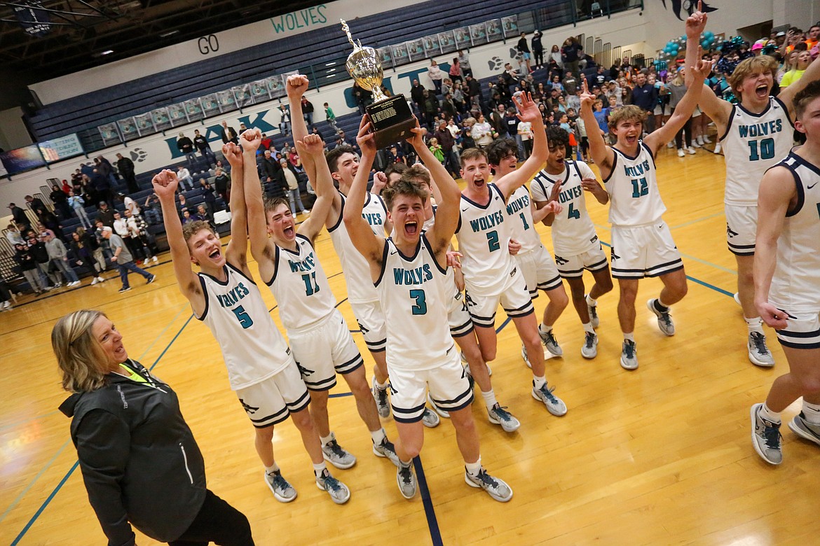 JASON DUCHOW PHOTOGRAPHY
Senior Miles Jones holds the trophy as the Lake City Timberwolves celebrate their 5A Region 1 boys basketball title after beating the Lewiston Bengals 77-28 on Tuesday night at Lake City.