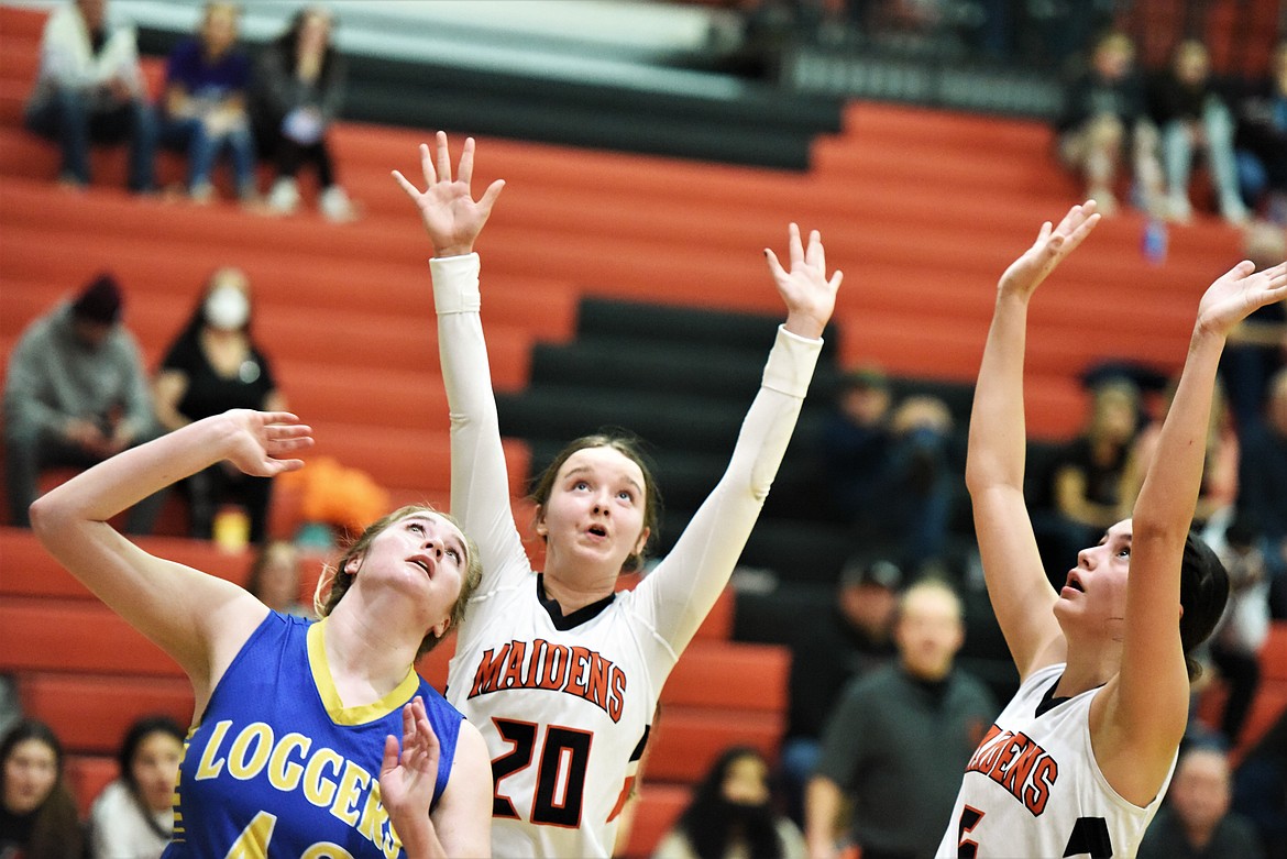 Ronan's Dani Coffman (20) and LaReina Cordova battle for position with Libby's Taylor Munro. (Scot Heisel/Lake County Leader)