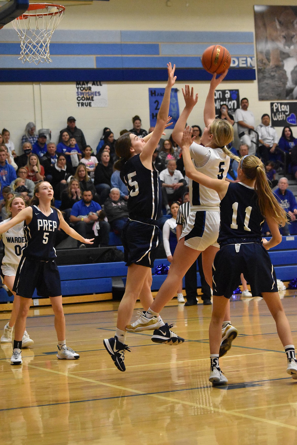 Warden High School senior Jaryn Madsen (5) attempts a basket while Tri-Cities Prep senior Janey Pedersen (15) and senior Claire Potter (11) attempt to block the shot on Feb. 12.