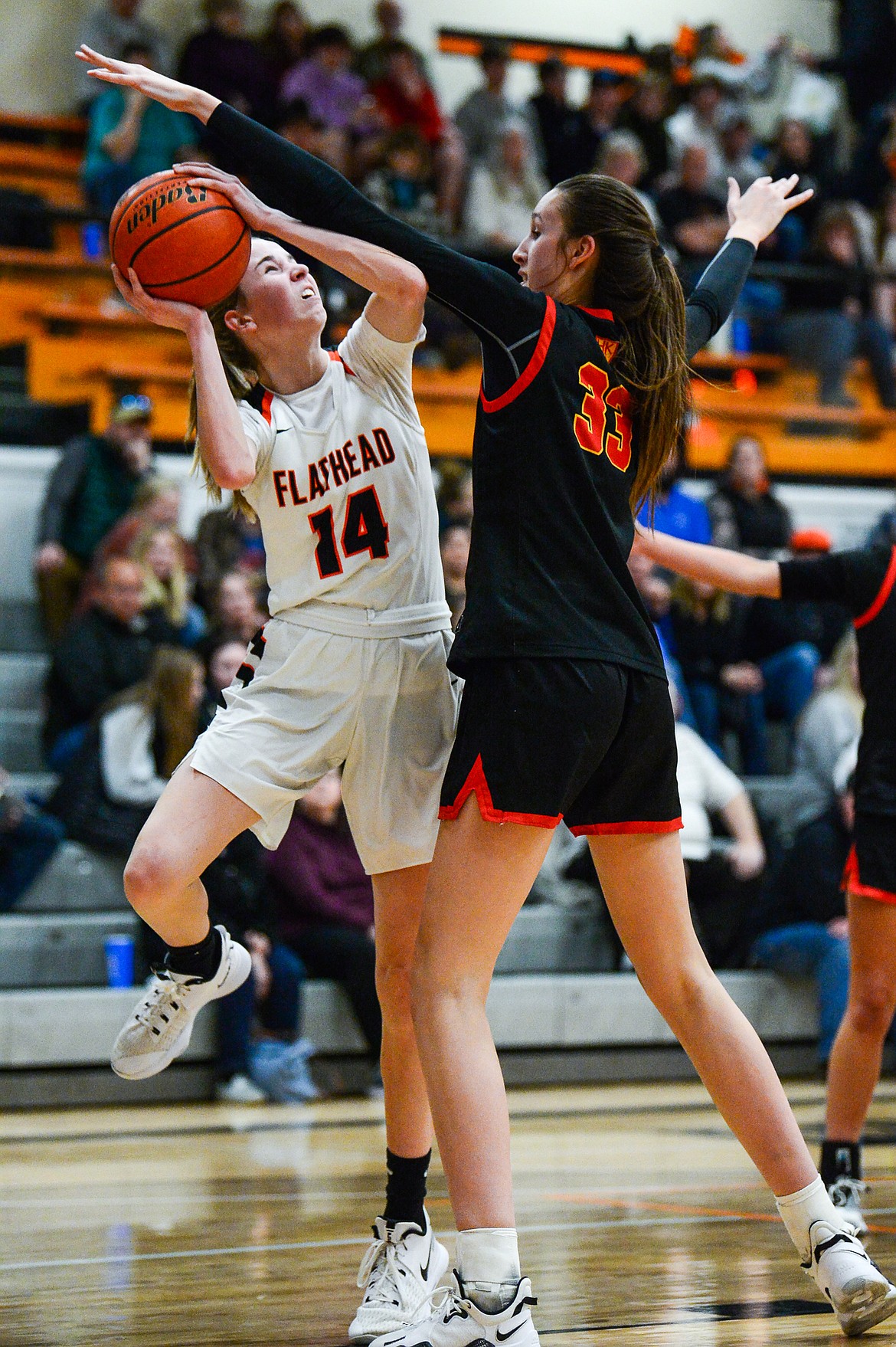 Flathead's Kennedy Moore (14) looks to shoot guarded by Missoula Hellgate's Alex Covill (33) at Flathead High School on Thursday, Feb. 24. (Casey Kreider/Daily Inter Lake)