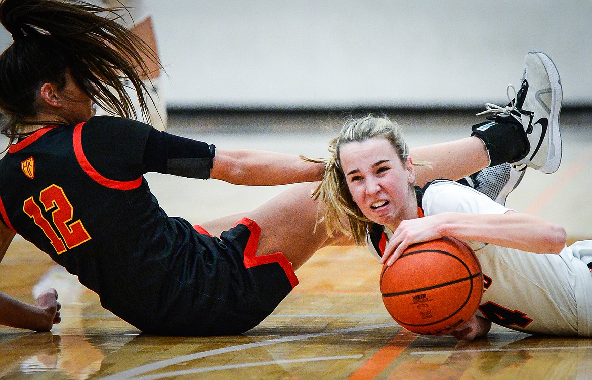 Flathead's Kennedy Moore (14) battles for a loose ball with Missoula Hellgate's Perry Paffhausen (12) at Flathead High School on Thursday, Feb. 24. (Casey Kreider/Daily Inter Lake)