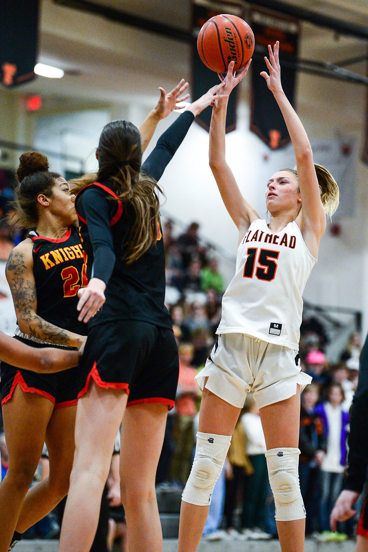 Flathead's Clare Converse (15) looks to shoot over Missoula Hellgate's Keke Davis (24) and Alex Covill (33) at Flathead High School on Thursday, Feb. 24. (Casey Kreider/Daily Inter Lake)