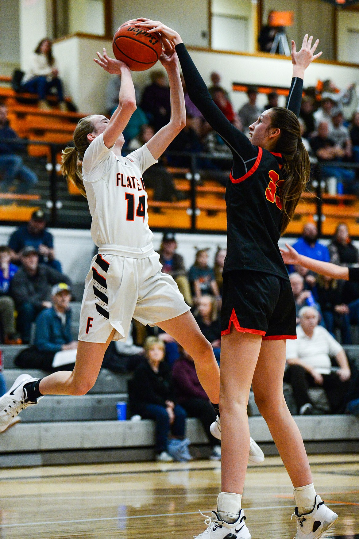 Flathead's Kennedy Moore (14) has a shot blocked by Missoula Hellgate's Alex Covill (33) at Flathead High School on Thursday, Feb. 24. (Casey Kreider/Daily Inter Lake)