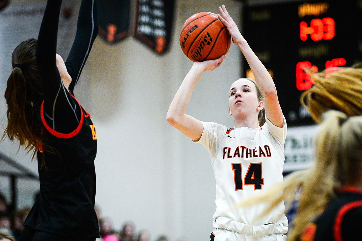 Flathead's Kennedy Moore (14) looks to shoot guarded by Missoula Hellgate's Alex Covill (33) at Flathead High School on Thursday, Feb. 24. (Casey Kreider/Daily Inter Lake)