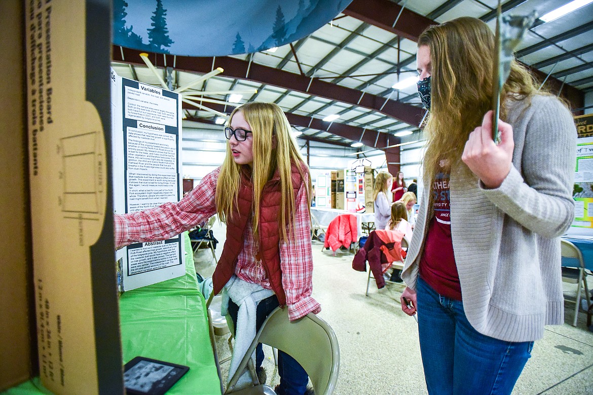 Maggie Fullerton, a fifth-grader at Glacier Gateway Elementary School, explains her project titled "The Effects of Roadside Dust on Tree Growth" to judge Stephanie Hummel at the Flathead County Science Fair on Thursday, Feb. 24. (Casey Kreider/Daily Inter Lake)