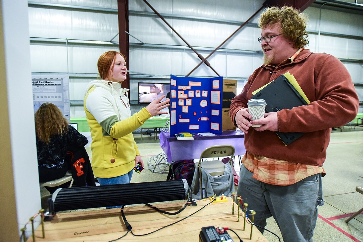 Emily Lockhart, an eighth-grader from Trinity Lutheran School, discusses her project with Troy Smith, an engineering teacher at Glacier High School, at the Flathead County Science Fair on Thursday, Feb. 24. Lockhart's project titled "Zap That Wire" dealt with what type of wire conducts the most electricity between steel, stainless steel, aluminum and copper. (Casey Kreider/Daily Inter Lake)