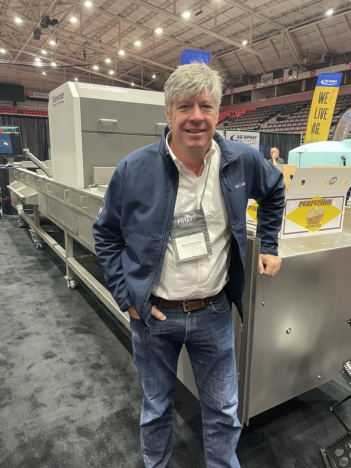 Boomer Batchman, president of Exeter Engineering, stands beside one of his company’s processing machines at the Washington Oregon Potato Conference in Kennewick in late January. Exeter also designs AI systems to help spot defects in potatoes.