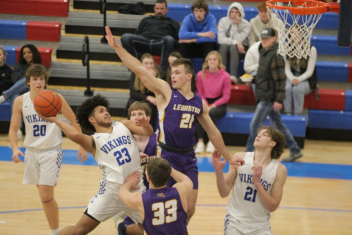 MARK NELKE/Press
Steven Burgess (23) puts up a shot in the lane as Cruz Hepburn (21) of Lewiston defends in the 5A Region 1 boys basketball second-place game Thursday night at Viking Court.