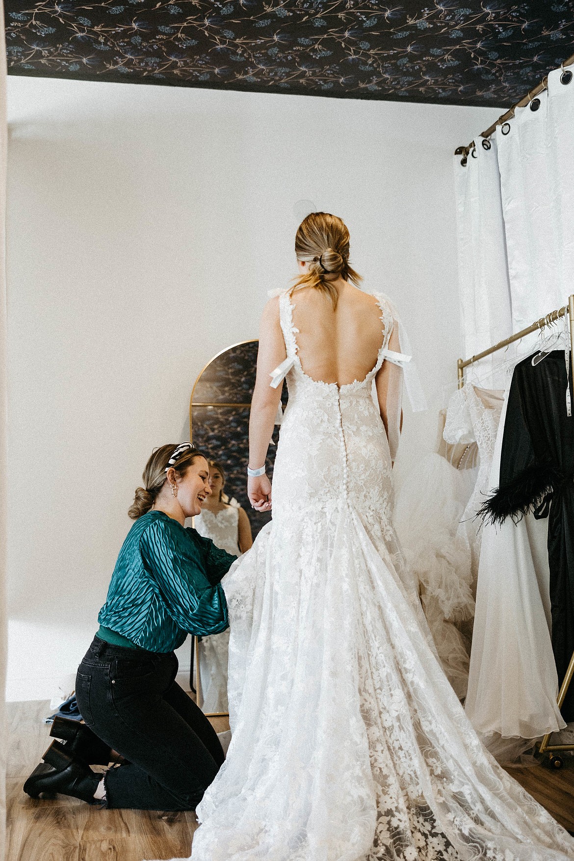 Hannah Hill, owner of Heirloom Bridal, left, works with a woman trying on a gown. Photo by Abi Noel Photography