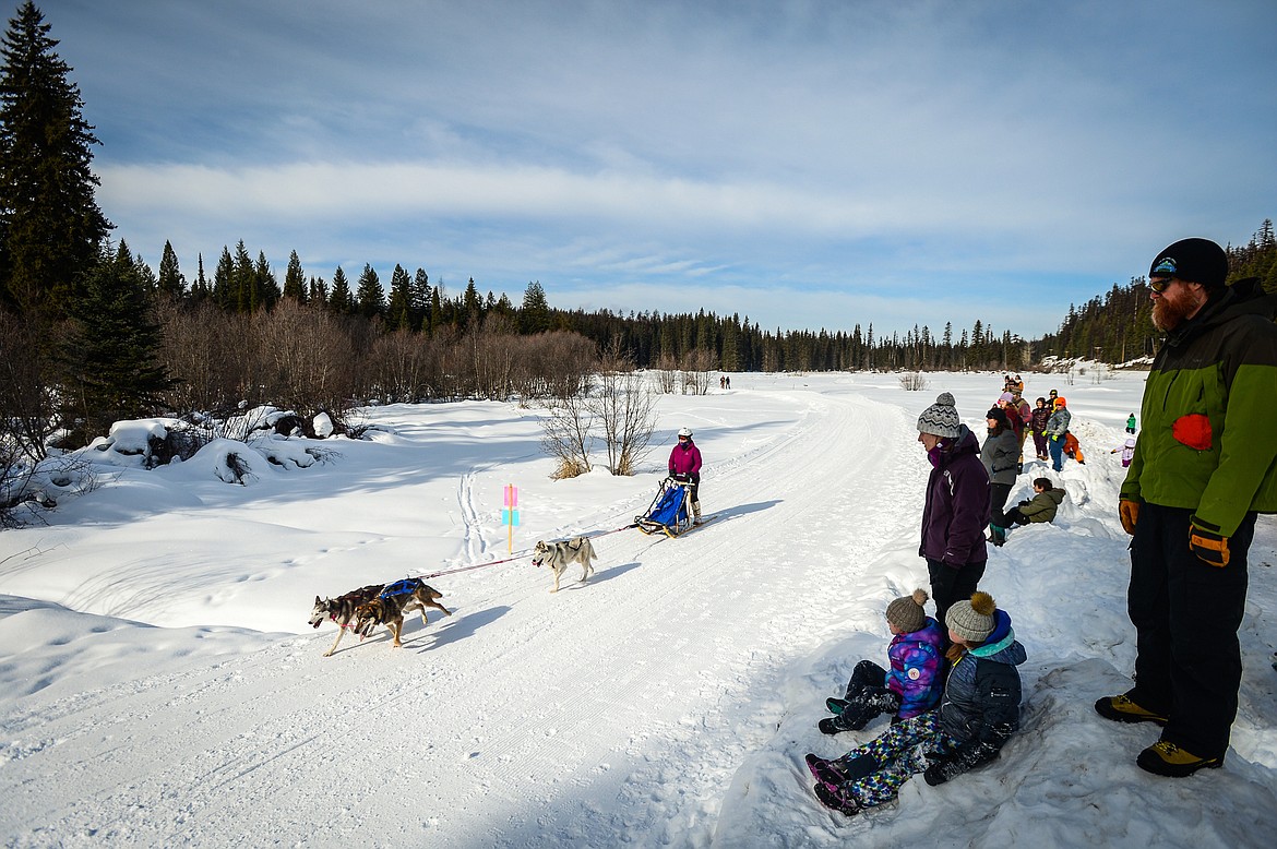 Spectators watch as a musher leads her three-dog team through the course at the Flathead Classic Sled Dog Race at Dog Creek Lodge & Nordic Center in Olney on Saturday, Feb. 26, 2022. (Casey Kreider/Daily Inter Lake FILE)