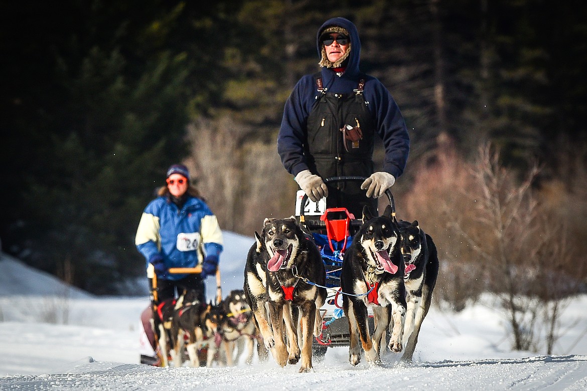 Mushers Jackson Casaus and Jill Thyr lead their four-dog teams through the course at the Flathead Classic Sled Dog Race at Dog Creek Lodge & Nordic Center in Olney on Saturday, Feb. 26. (Casey Kreider/Daily Inter Lake)