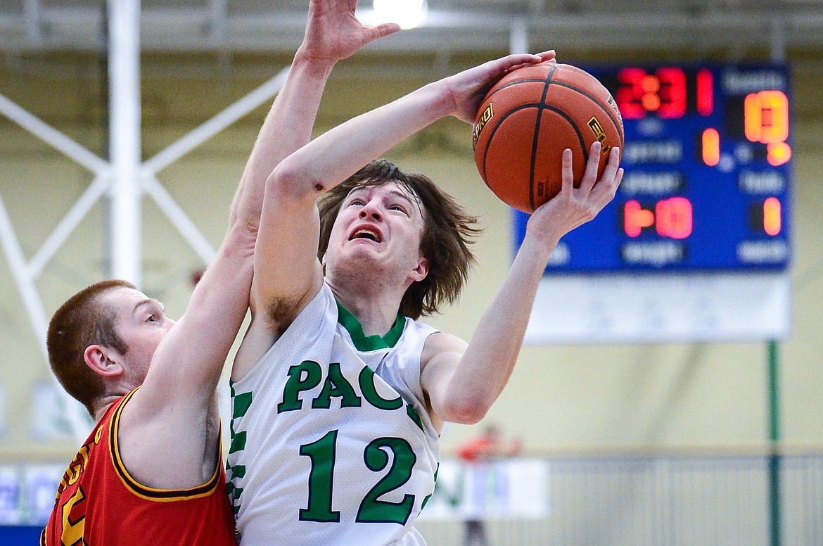 Glacier's Kyson Wagner (12) goes to the basket against Missoula Hellgate's Griffin Kinch (5) at Glacier High School on Saturday, Feb. 26. (Casey Kreider/Daily Inter Lake)