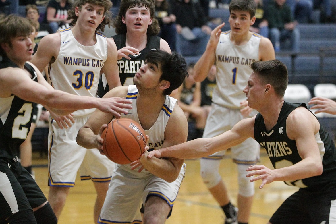 MARK NELKE/Press
Antonio Mayorga (25) of Clark Fork tries to go up for a shot through the defense of Logan Hunter, left, and Micah Nelson of Timberline of Weippe during a 1A Division II boys basketball state play-in game Saturday at Lake City High.